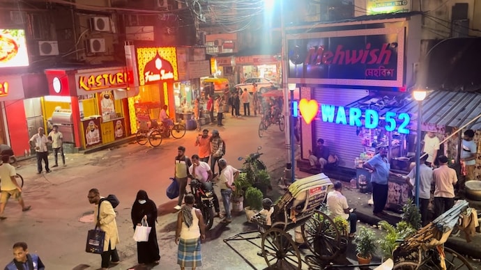 A bustling commercial street filled with hotels and retail shops in Kolkata.